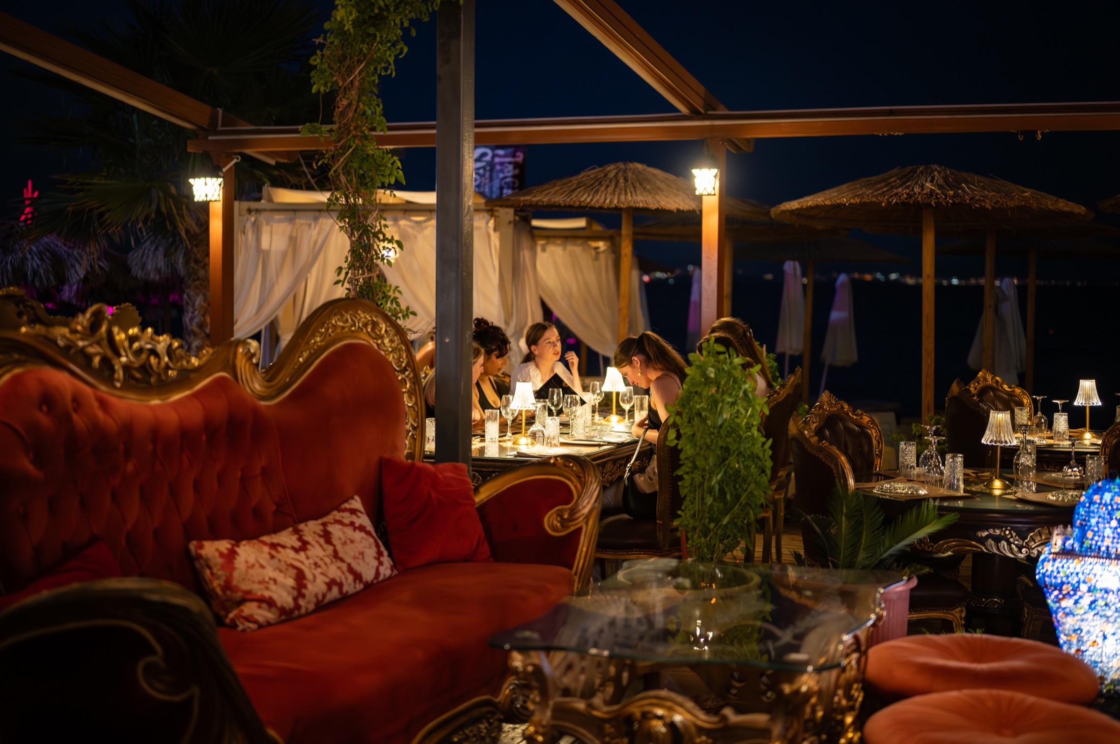 Guests sharing an evening at Harem among red velvet sofas and warm table lights